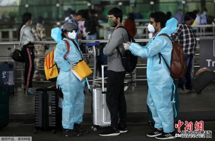 5月25日，在印度孟买希拉吉国际机场，旅客们穿戴着防护服和面罩出行。 印度政府允许国内航线自5月25日起恢复。